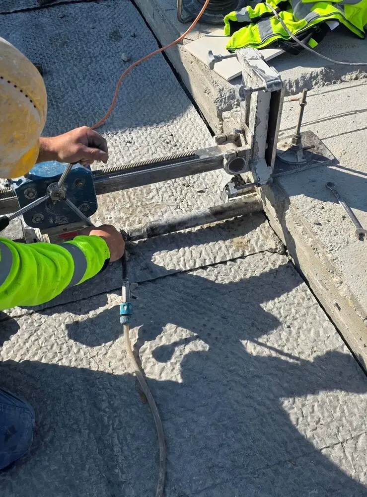 Operator wiertnicy rdzeniowej podczas wiercenia otworów w betonie, realizacja KDZ