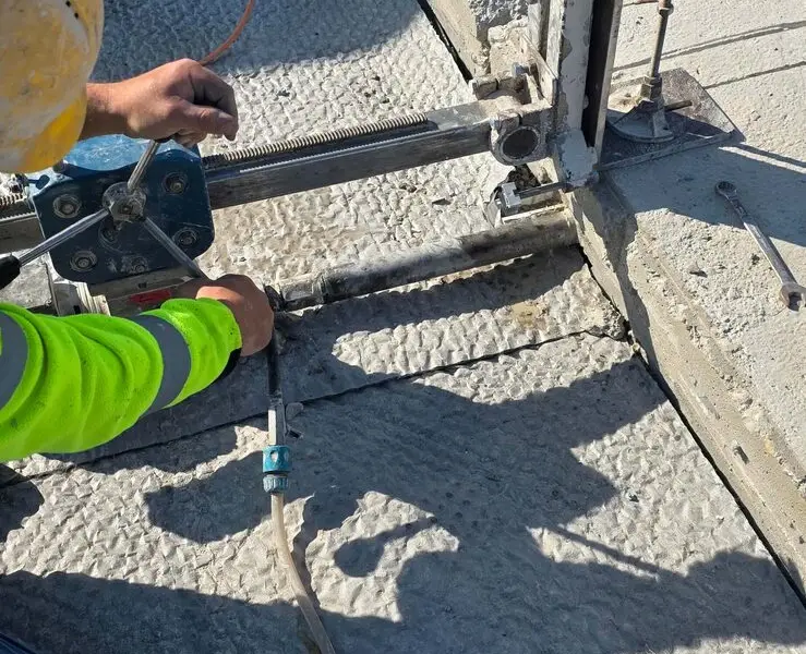 Operator wiertnicy rdzeniowej podczas wiercenia otworów w betonie, realizacja KDZ